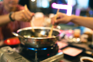 Blur background of people having a hot pot. Sukiyaki hot pot boiled