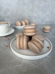 Chocolate Macarons with Coffee Cream Filling on Ceramic Plate