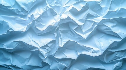 Crumpled blue paper texture showcasing intricate folds and creases in natural light for artistic backgrounds