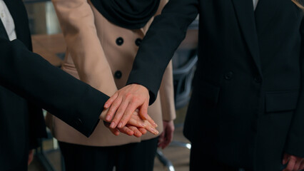 Obraz premium Multiracial women business colleagues three multiethnic businesswomen girls Caucasian Asian Muslim ladies ethnic different unite happy office team stack female hands together partnership collaboration