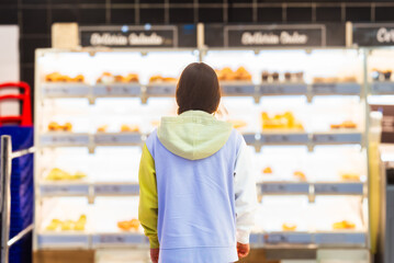 Woman viewing bakery section in a supermarket