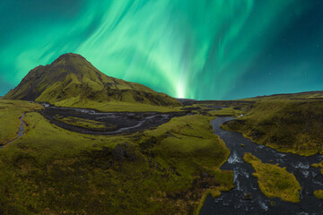 Aurora Borealis over lush Icelandic landscape