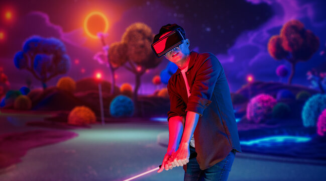 Skilled gamer wearing VR glasses while playing golf at metaverse or golf court with purple sky. Attractive golf player or athlete practicing sport skill while entering in simulated world. Ingenuity.