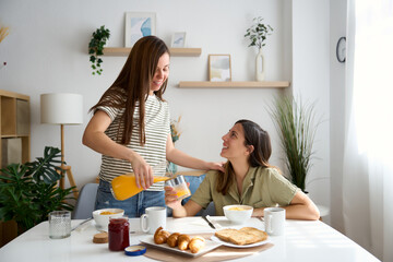 Lesbian couple enjoying breakfast together in cozy home