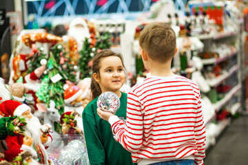 Family sister and brother shopping Christmas presents and decoration in shopping mall