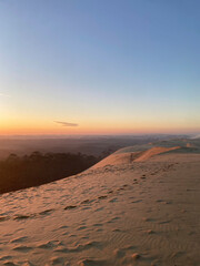 Dune du Pilat at sunrise, with the soft light illuminating the vast sandy landscape and creating a serene, natural atmosphere