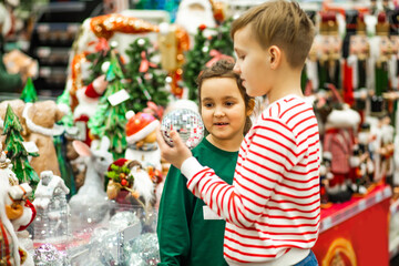 Family sister and brother shopping Christmas presents and decoration in shopping mall