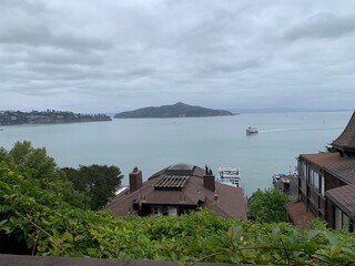 This photo captures a tranquil waterfront scene from a high vantage point, showcasing a boat cruising through the calm water near a small island.