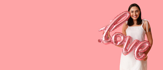 Beautiful young woman with air balloon in shape of word LOVE on pink background. Valentine's Day celebration