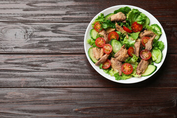 Delicious fresh tuna salad on wooden table, top view. Space for text