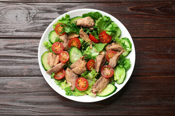 Delicious fresh tuna salad on wooden table, top view
