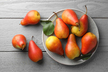 Ripe juicy pears on grey wooden table, flat lay