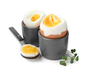 Soft boiled eggs and spoon isolated on white