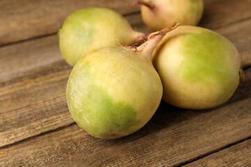 Whole fresh turnips on wooden table, closeup