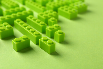 Constructor toy. Many building blocks on light green background, closeup