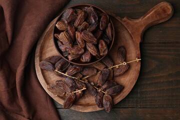 Tasty dried dates on wooden table, top view