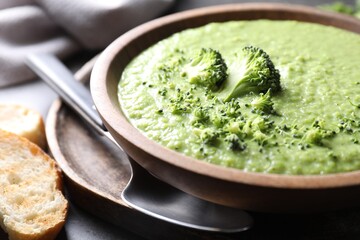 Delicious broccoli cream soup served on grey table, closeup
