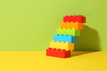 Naklejka premium Construction toy. Figure made with building bricks on color background, space for text