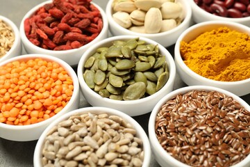 Different superfoods in bowls on table, closeup