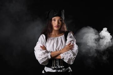 Beautiful young Asian woman dressed as pirate on black background