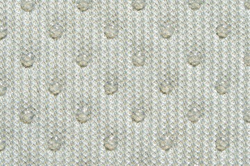 Textured beige fabric with raised dotted pattern close up.