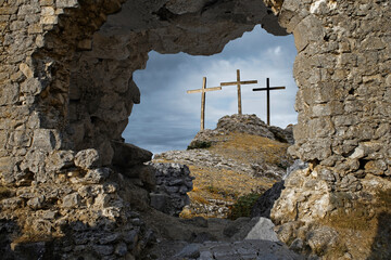 Three wooden crosses on hill against sky. Biblical scene, concept of Crucifixion on Mount Golgotha,...
