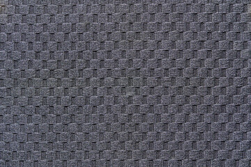 Close up of gray woven fabric with intricate geometric pattern.