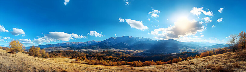 A panoramic view of the Carpathian Mountains, with mist rising from their peaks and sunlight shining through the blue sky
