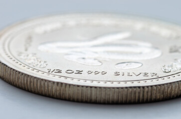 A fragment of a silver coin weighing 1/2 troy ounce. Selective focus.