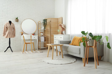 Stylish interior of light room with comfortable sofa and dressing table