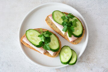 a plate with sandwiches with ham and cucumber slices top view 