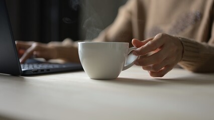 Relaxing Coffee Break While Working from Home at Cozy Office Desk with Laptop Warm Atmosphere Focus on Productivity and Comfort