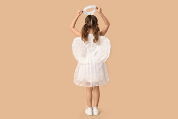 Little girl dressed as Cupid on brown background, back view. Valentine's Day celebration