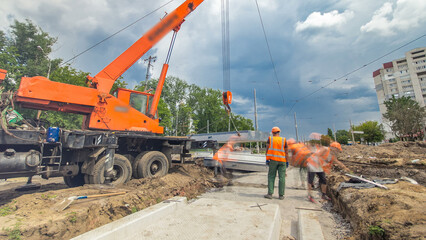 Installing concrete plates by crane at road construction site timelapse hyperlapse.