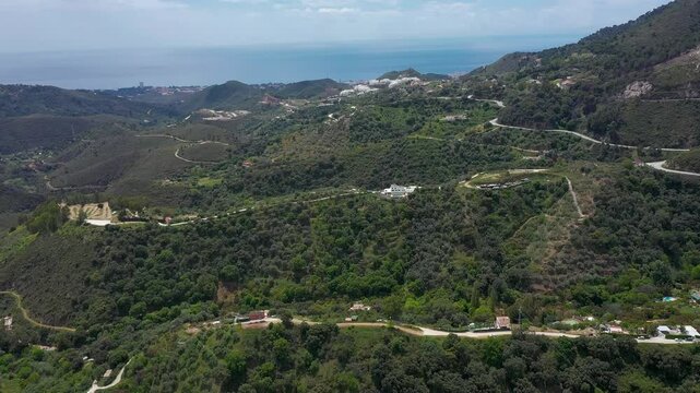 Countryside of Spain. View of area between Marbella and Ojen. Hills with different fields of agriculture. Small farms. In background is Mediterranean Sea and Marbella city. Costa del Sol. Forward