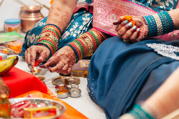 An Indian woman lights a brass oil lamp to worship a Hindu god during the Karwa Chauth festival.