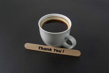 A cup of coffee with a word Thank You on black background