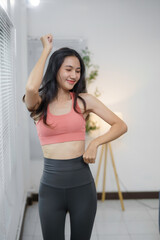 Happy asian sportswoman dancing joyfully while enjoying her invigorating home workout, embracing a vibrant and active lifestyle