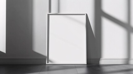 A blank white frame is positioned against a wall, illuminated by soft shadows from nearby windows.