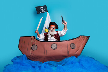 Photo of strong pirate in traditional costume swimming in the sea wooden old ship isolated on blue color background