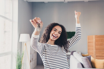 Photo of nice young girl buy apartment excited hold key wear striped clothes enjoy modern cozy...