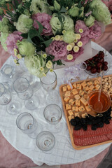 picnic with a bouquet of flowers and cheese snacks