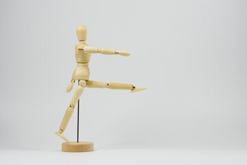 Wooden articulated figure marching representing military activities with a white background and space to put text