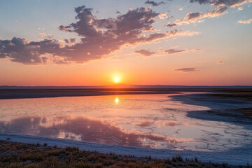 Fototapeta premium Breathtaking sunset over salt flats with reflective water and vibrant sky