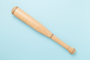 Wooden baseball bat on color background, top view