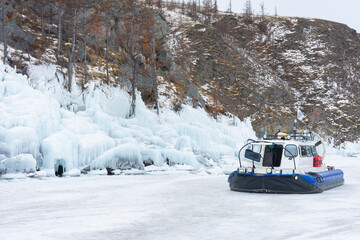 A white boat is on the water in the snow