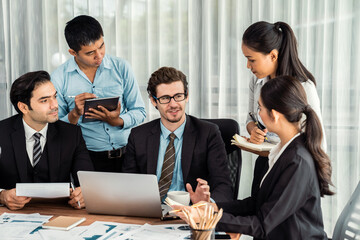Diverse of business people from various ethnic group working in modern office environment. Productive and multi ethnic office workers engage in discussion for strategic business marketing. Meticulous