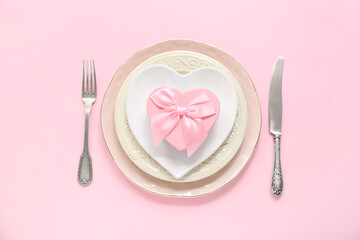 Beautiful table setting with gift box on pink background. Valentine's Day celebration