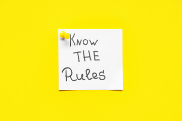Pinned paper with text KNOW THE RULES on yellow background