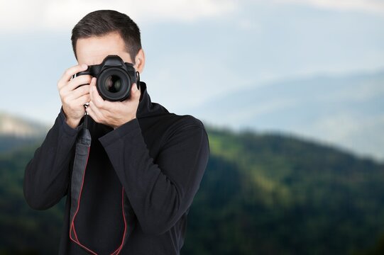 Happy photographer with modern camera take photo outdoors